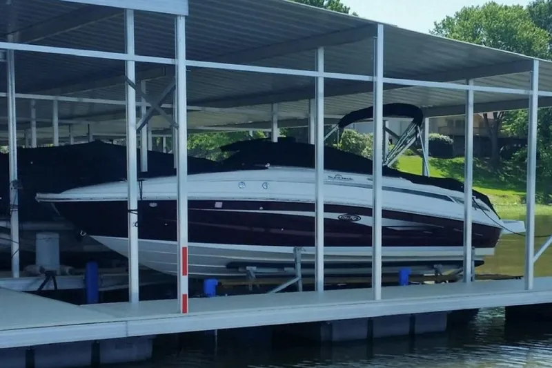 Slide: The Image of 2012 Sea Ray 240 Sundeck boat docked under covered marina. - 9