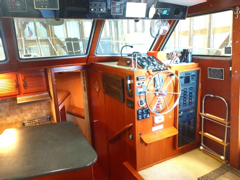Slide: The Image of 1981 Tollycraft 43 Motoryacht helm with wooden interior, steering wheel, and control panels. - 10