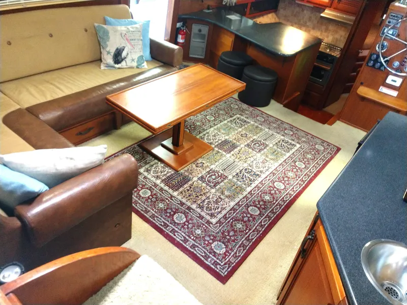 Slide: The Image of Interior of 1981 Tollycraft 43 Motoryacht with cozy seating, wooden table, and decorative rug. - 12