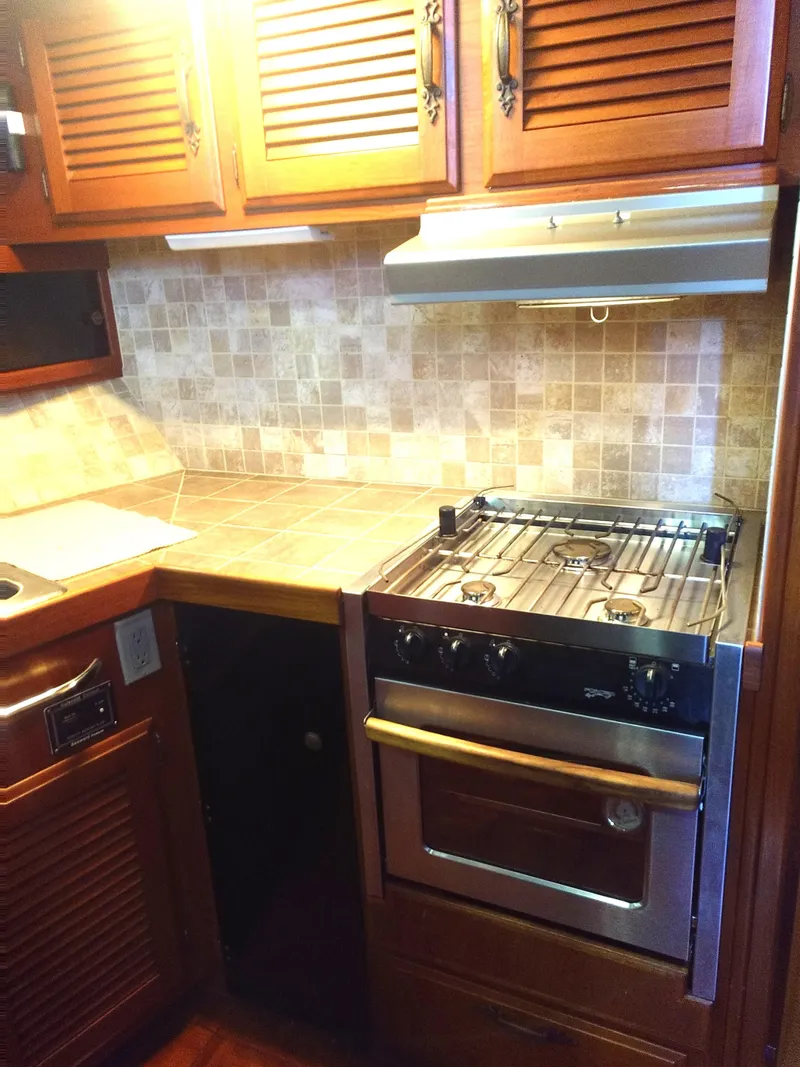 Slide: The Image of 1981 Tollycraft 43 Motoryacht kitchen with wooden cabinets and a gas stove. - 18