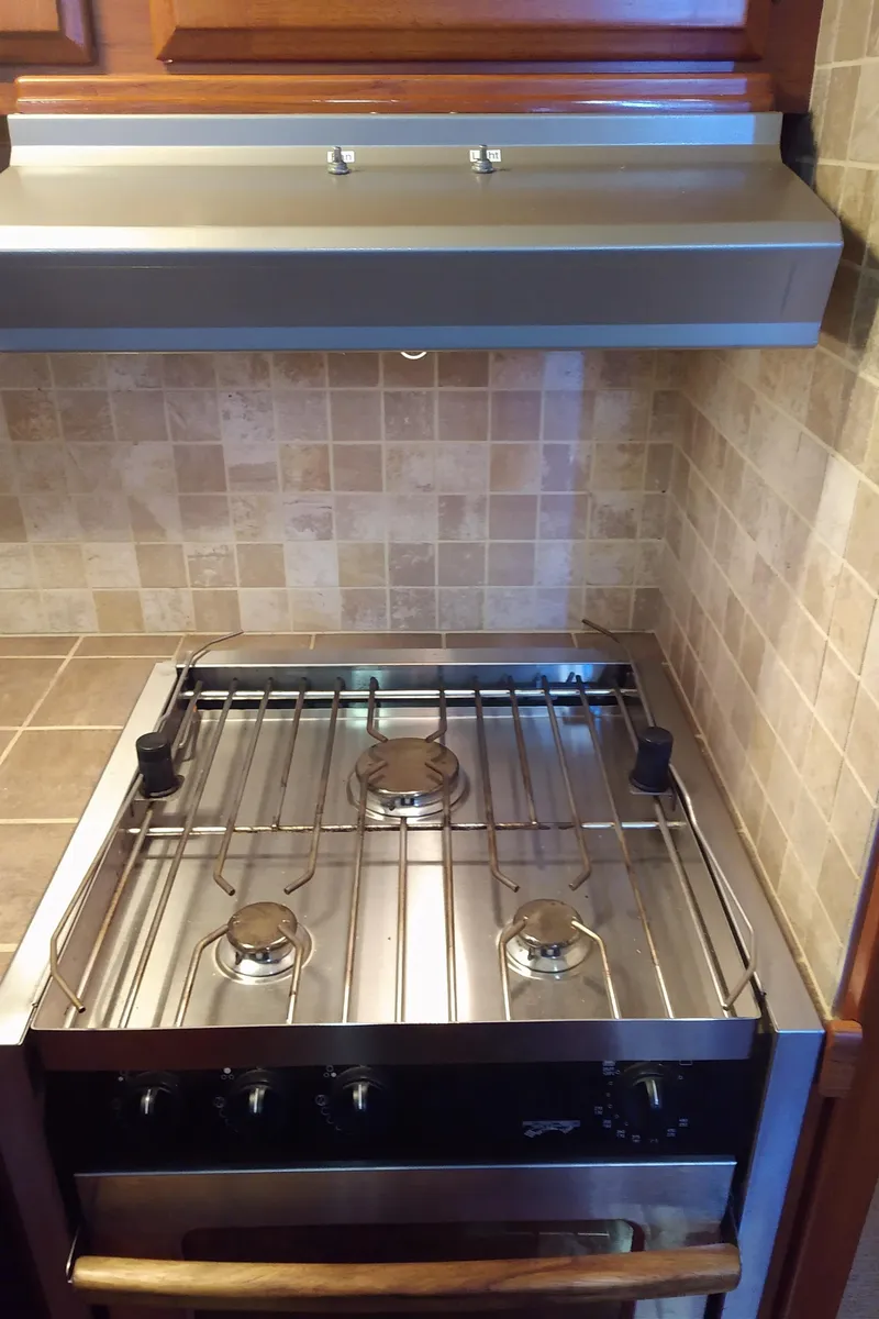 Slide: The Image of Stove in 1981 Tollycraft 43 Motoryacht kitchen with tiled backsplash and wooden cabinetry. - 19