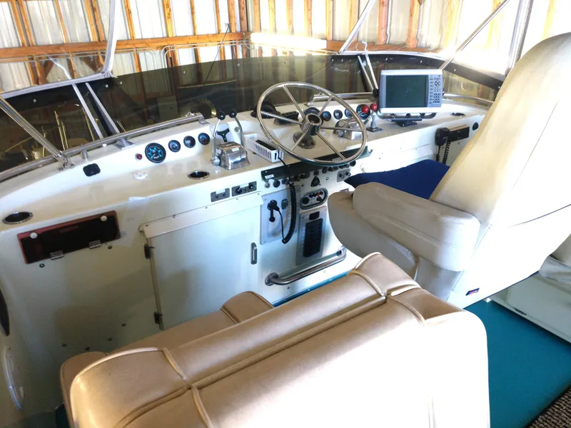 Slide: The Image of 1981 Tollycraft 43 Motoryacht helm with steering wheel, gauges, and navigation equipment in a cabin setting. - 2