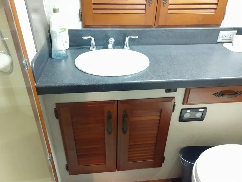 Slide: The Image of 1981 Tollycraft 43 Motoryacht bathroom with sink, wooden cabinets, and countertop. - 28