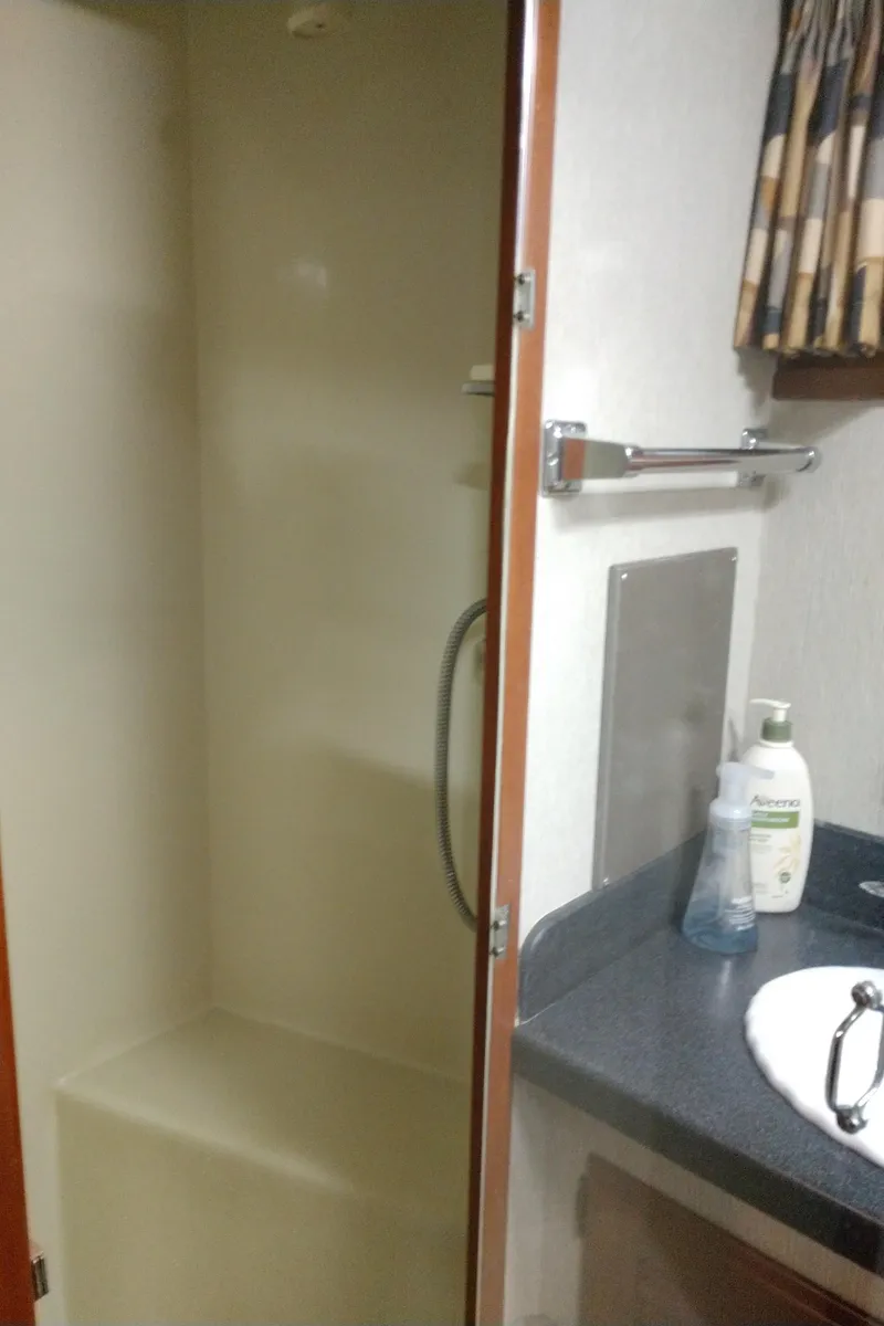 Slide: The Image of 1981 Tollycraft 43 Motoryacht bathroom with shower, sink, and toiletries. - 29