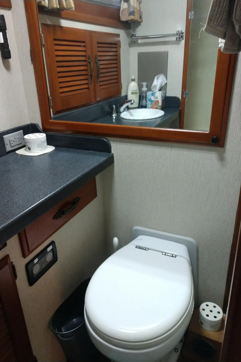 Slide: The Image of 1981 Tollycraft 43 Motoryacht bathroom with toilet, sink, mirror, and storage cabinets. - 34