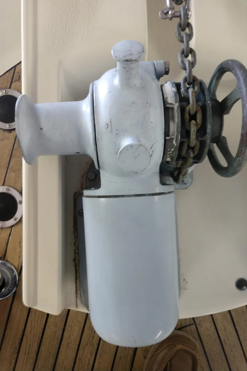 Slide: The Image of Anchor windlass on 1981 Tollycraft 43 Motoryacht deck, featuring chain and wooden flooring. - 48
