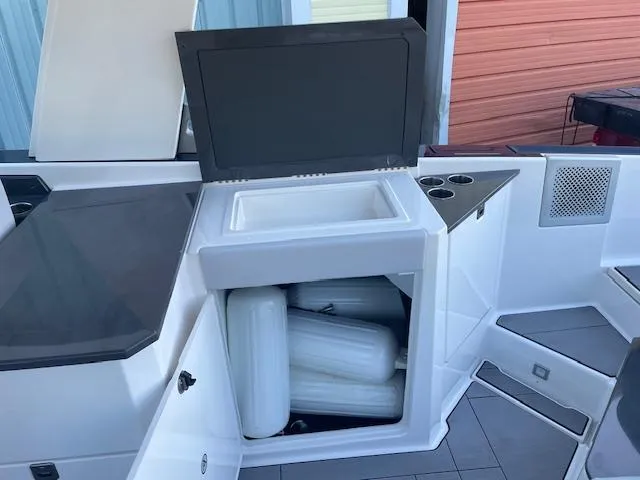 Slide: The Image of 2022 Aviara AV 32-OB boat interior with storage compartment and cup holders. - 23