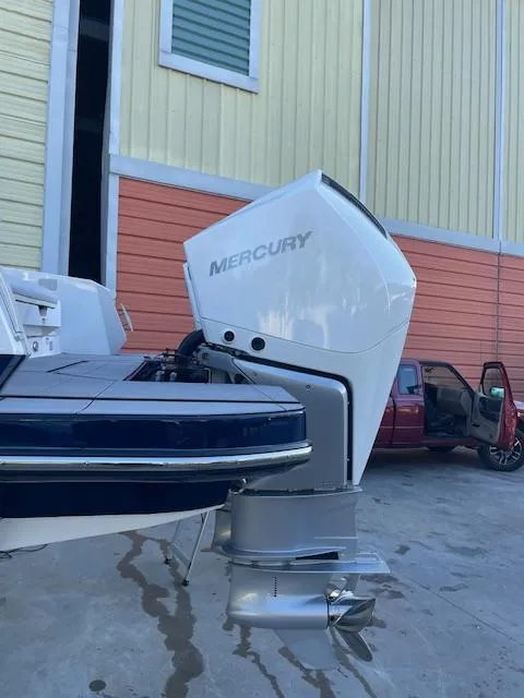 Slide: The Image of 2022 Aviara AV 32-OB boat with Mercury outboard motor, parked near a colorful building. - 5