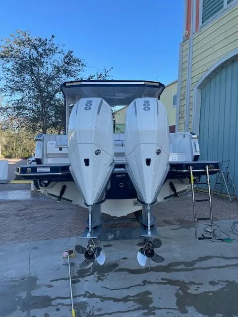 Slide: The Image of 2022 Aviara AV 32-OB boat with dual outboard engines, parked near a building. - 6