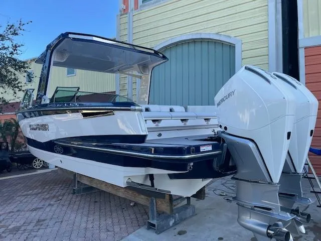 Slide: The Image of 2022 Aviara AV 32-OB boat with dual Mercury outboard engines, docked outdoors. - 3