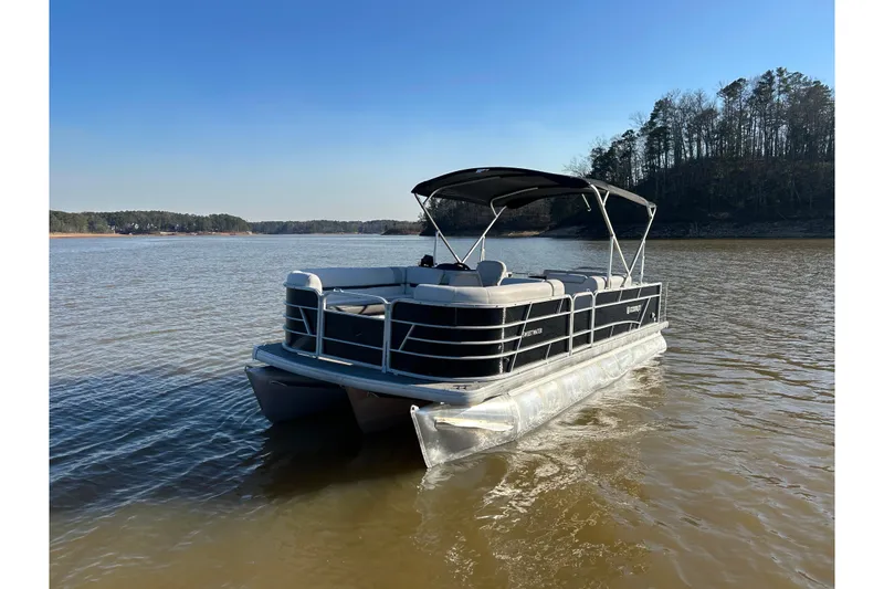 Slide: The Image of 2022 Godfrey Sweetwater 2286 C pontoon boat on a serene lake. - 1