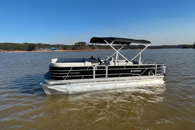 Slide: The Image of 2022 Godfrey Sweetwater 2286 C pontoon boat on a calm lake. - 2