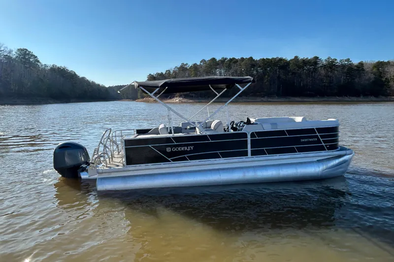 Slide: The Image of 2022 Godfrey Sweetwater 2286 C pontoon boat on a serene lake. - 7