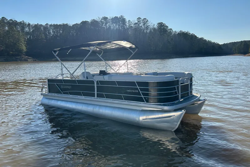 Slide: The Image of 2022 Godfrey Sweetwater 2286 C pontoon boat on a serene lake. - 8