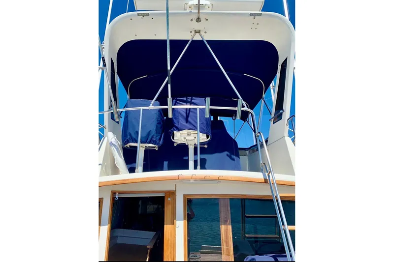 Slide: The Image of 1987 Egg Harbor 43 Sport Fisherman boat with blue canopy and ladder. - 10