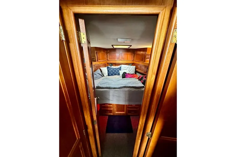 Slide: The Image of Cozy cabin interior of 1987 Egg Harbor Sportfisher with wooden paneling and comfortable bedding. - 21