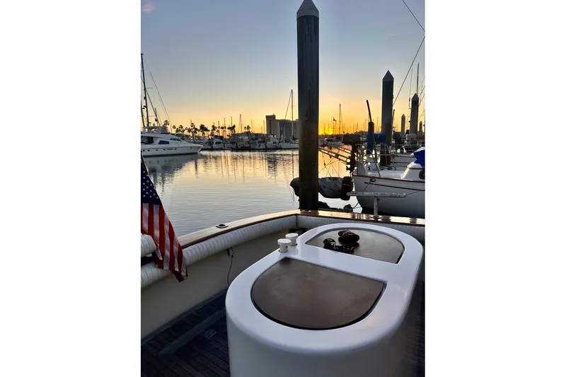Slide: The Image of 1987 Egg Harbor 43 Sport Fisherman at sunset in marina, with American flag. - 27
