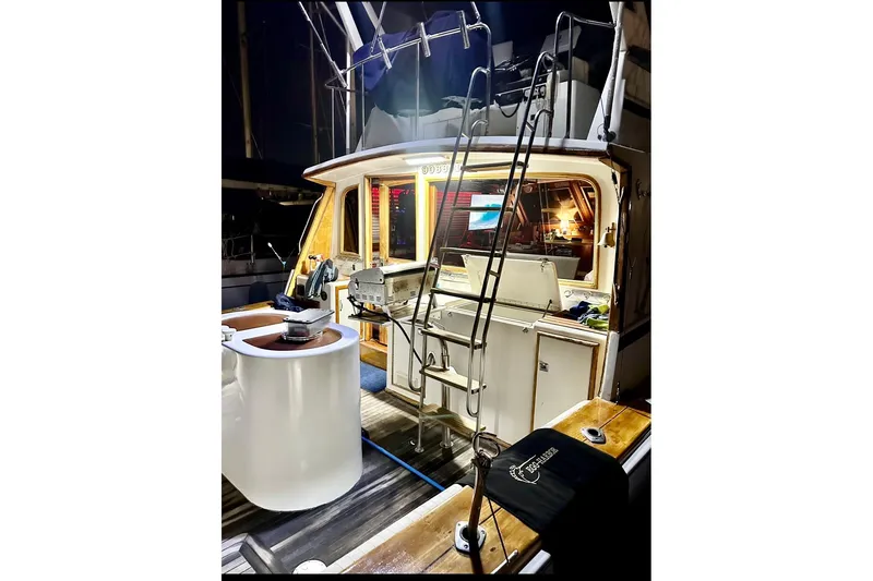 Slide: The Image of 1987 Egg Harbor 43 Sport Fisherman boat interior with fishing equipment and ladder at night. - 5