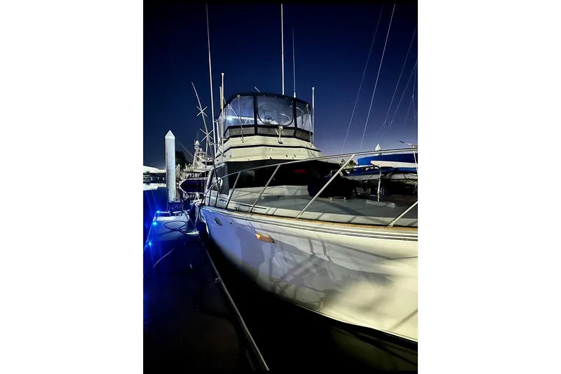 Slide: The Image of 1987 Egg Harbor 43 Sport Fisherman yacht docked at night, illuminated by blue lights. - 6