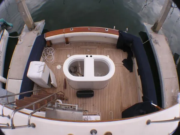 Slide: The Image of 1987 Egg Harbor Sportfisher interior with fishing gear, TV, and cozy wooden decor. - 12