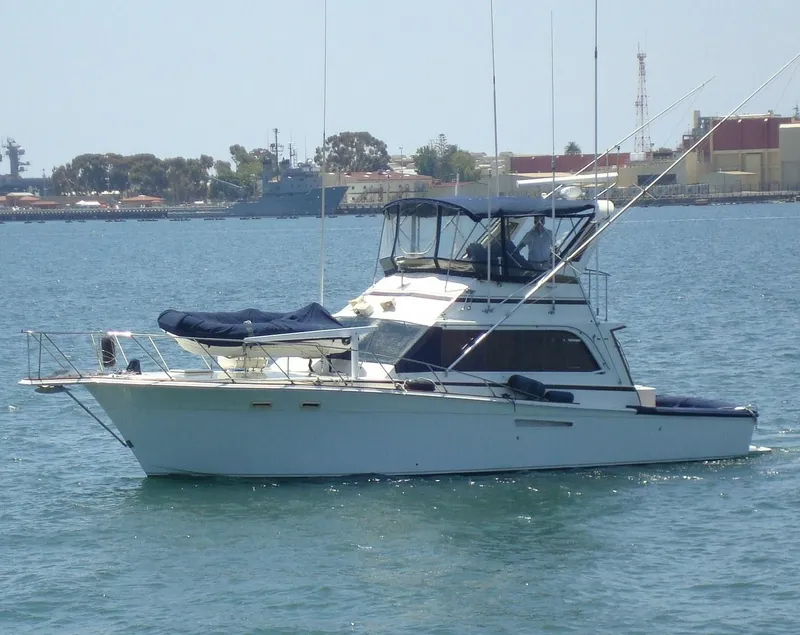 Slide: The Image of 1987 Egg Harbor Sportfisher boat on calm water, featuring a classic design and fishing equipment. - 2