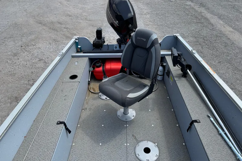 Slide: The Image of 2023 Lund 1600 Fury Tiller boat interior with seat and motor, showcasing fishing setup. - 7