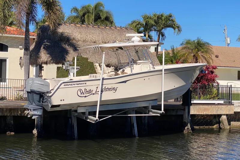 The Image of 2006 Grady-White Bimini 306 boat named "White Lightning" docked near waterfront home. - 0