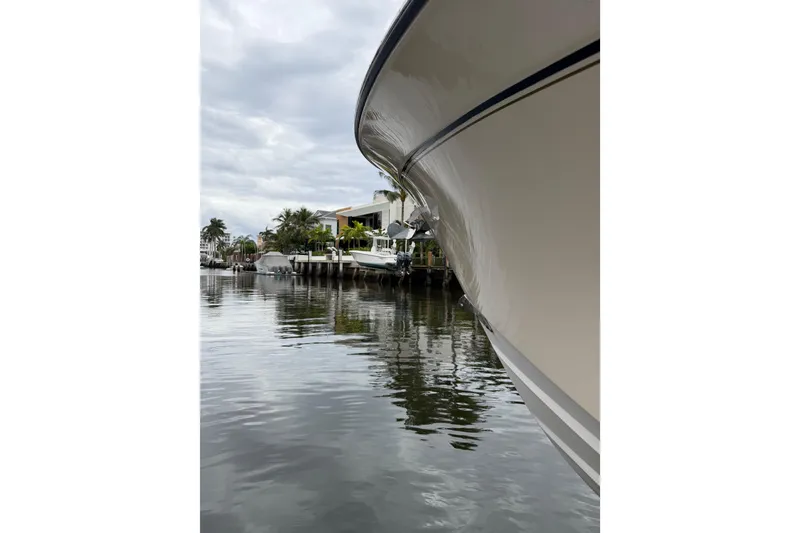 Slide: The Image of 2006 Grady-White Bimini 306 boat with covered Yamaha engines docked by a waterfront. - 11