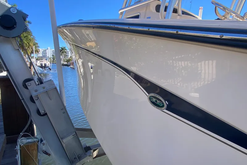 Slide: The Image of 2006 Grady-White Bimini 306 boat docked on calm water, side view. - 13