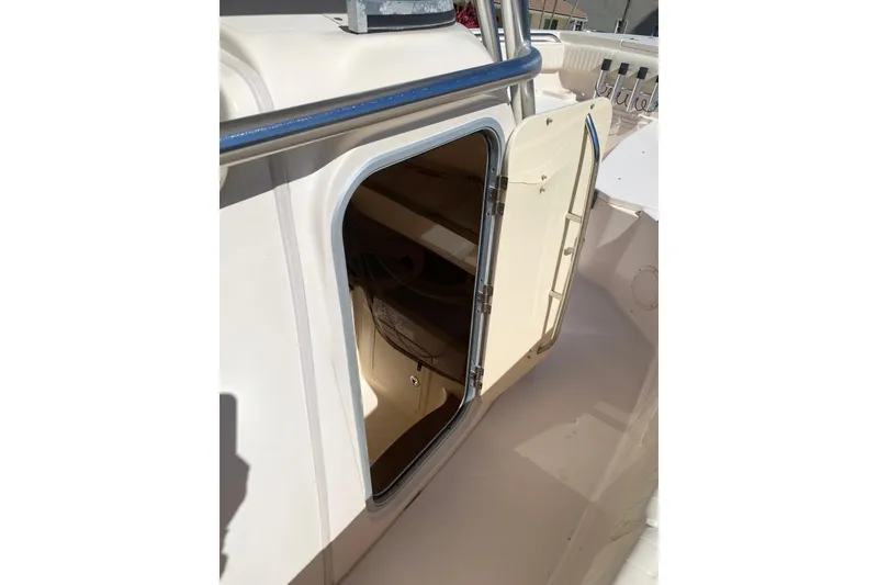 Slide: The Image of 2006 Grady-White Bimini 306 boat cabin door open, showing interior storage space. - 16