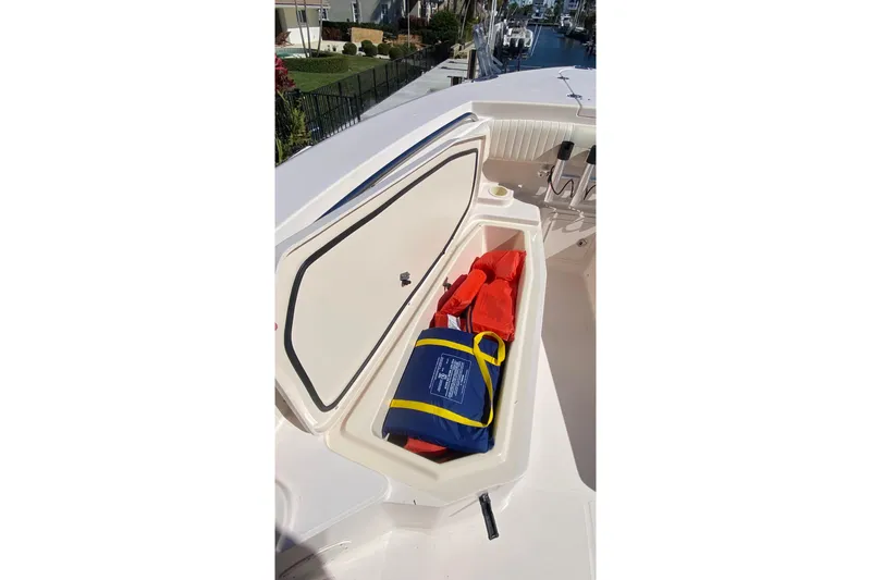 Slide: The Image of Open storage compartment on 2006 Grady-White Bimini 306 boat with life jackets inside. - 18