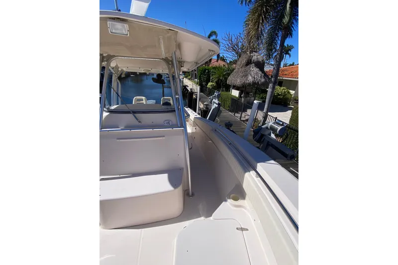 Slide: The Image of 2006 Grady-White Bimini 306 boat docked near palm trees and waterfront homes. - 20