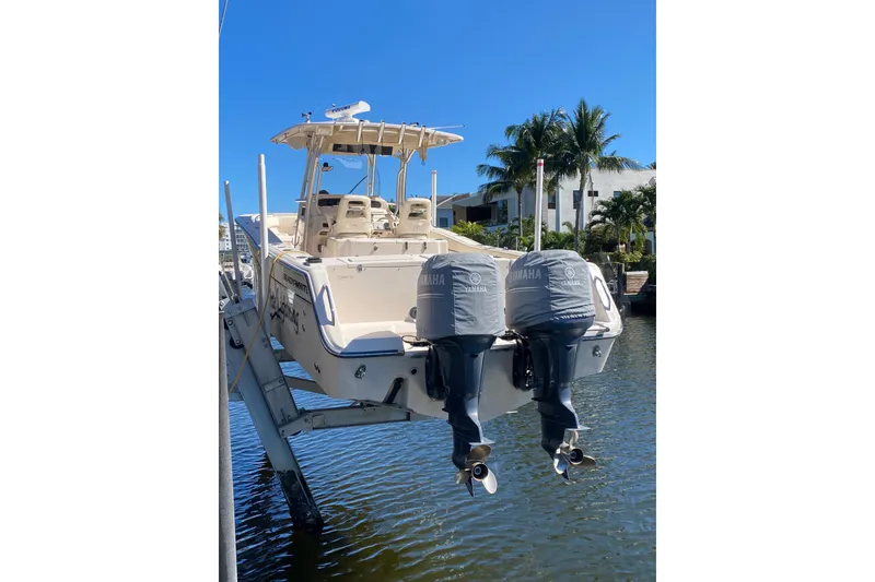 Slide: The Image of 2006 Grady-White Bimini 306 boat with twin Yamaha engines on a lift by the water. - 25