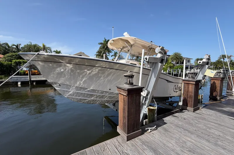 Slide: The Image of 2006 Grady-White Bimini 306 boat docked on a lift, surrounded by tropical scenery. - 33