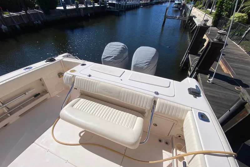 Slide: The Image of 2006 Grady-White Bimini 306 boat, featuring spacious deck and sleek design, docked by waterfront. - 8