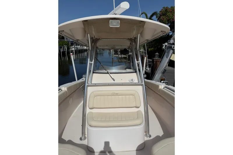 Slide: The Image of 2006 Grady-White Bimini 306 boat interior with seating and canopy, docked by calm water. - 18