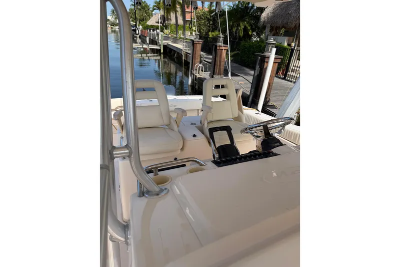 Slide: The Image of 2006 Grady-White Bimini 306 boat interior with helm and seating, docked by waterfront. - 5