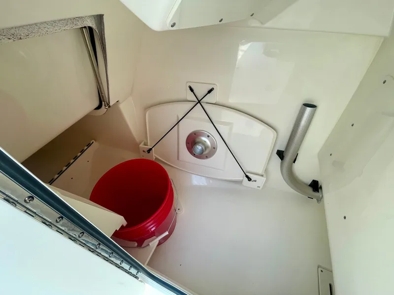 Slide: The Image of Interior of a Boston Whaler 240 Vantage with a red bucket and storage space. - 18