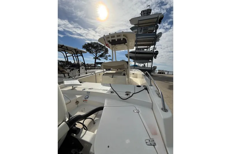 Slide: The Image of 2020 Boston Whaler 240 Dauntless boat docked under a bright sunlit sky. - 12
