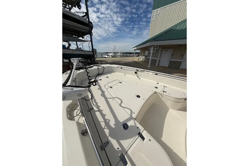 Slide: The Image of 2020 Boston Whaler 240 Dauntless boat docked, showcasing spacious deck and modern design. - 16