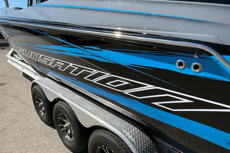 Slide: The Image of 2026 Sunsation 32 CCX boat with blue and black design on a trailer. - 11
