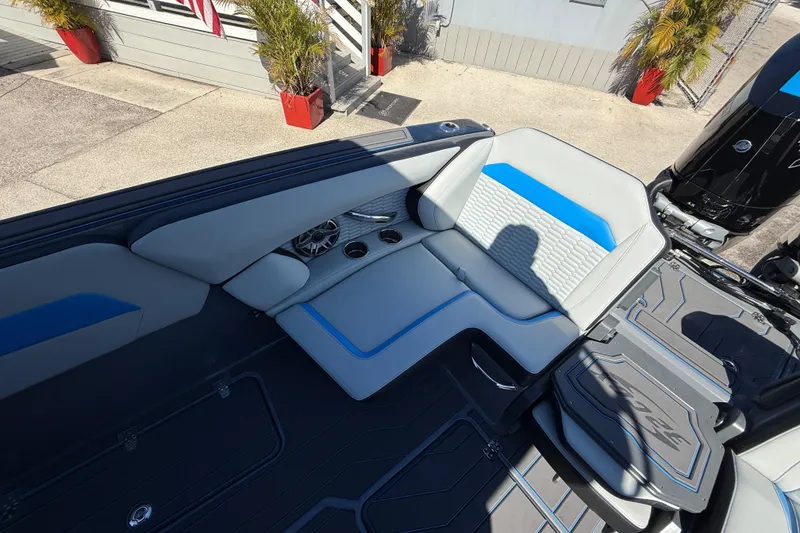 Slide: The Image of 2026 Sunsation 32 CCX boat interior with gray and blue seating, cup holders, and modern design. - 18