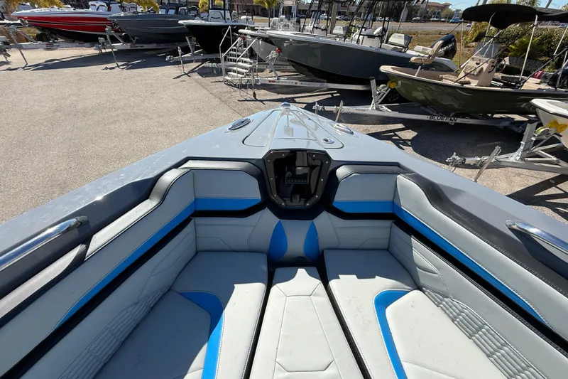 Slide: The Image of 2026 Sunsation 32 CCX boat interior with blue and gray seating, parked among other boats. - 31