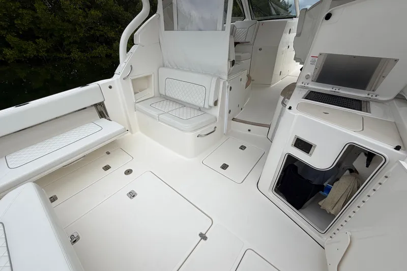 Slide: The Image of 2024 Pursuit DC 365 Dual Console boat interior with seating and storage compartments. - 10