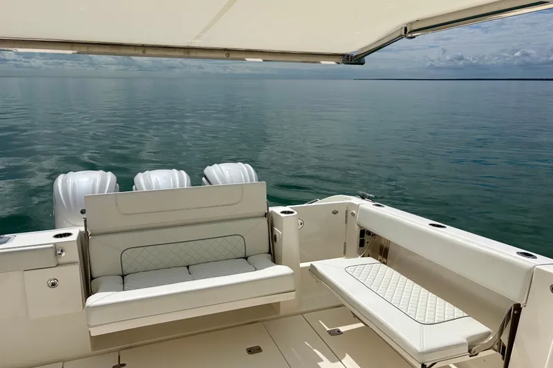 Slide: The Image of 2024 Pursuit DC 365 Dual Console boat with luxurious seating on calm waters. - 13