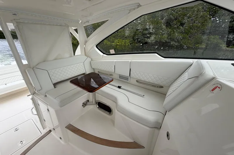 Slide: The Image of Luxurious interior of 2024 Pursuit DC 365 Dual Console boat with elegant seating and table. - 14