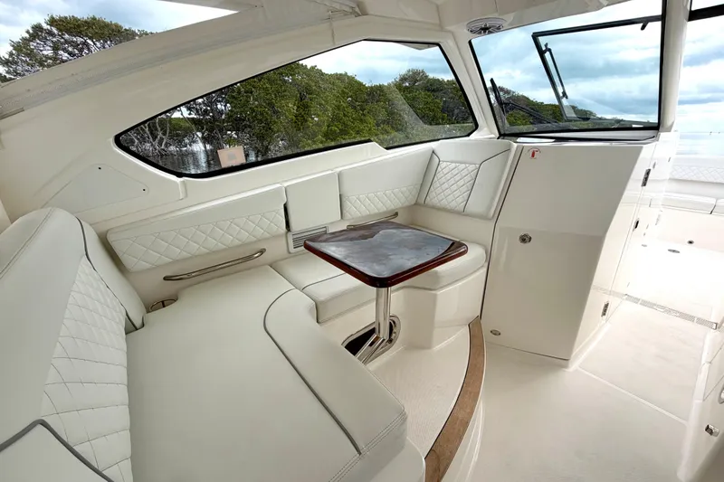 Slide: The Image of Luxurious interior of 2024 Pursuit DC 365 Dual Console boat with elegant seating and table. - 15