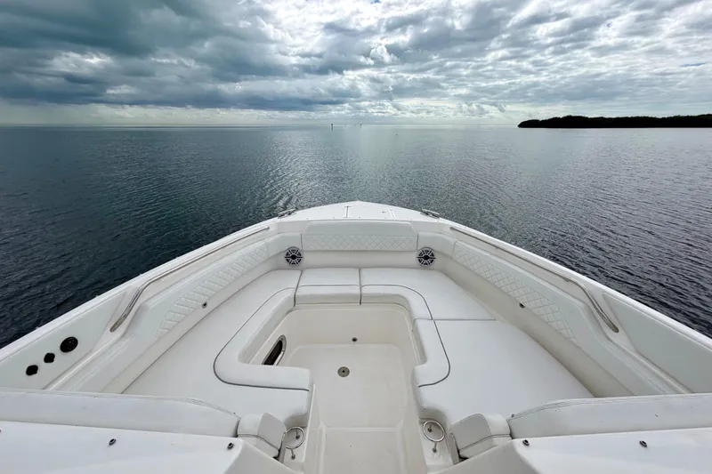 Slide: The Image of 2024 Pursuit DC 365 Dual Console boat on calm water under cloudy sky. - 20