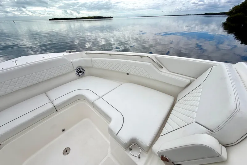 Slide: The Image of 2024 Pursuit DC 365 Dual Console boat with luxurious white seating on calm water. - 22