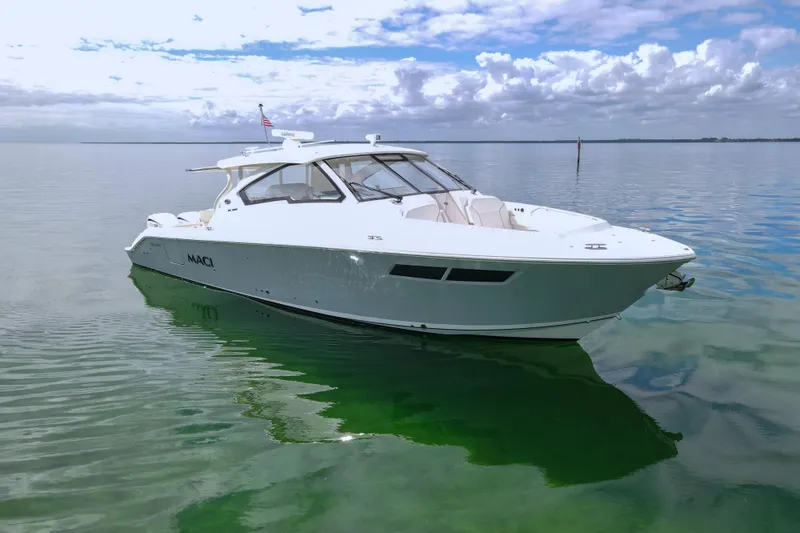 Slide: The Image of 2024 Pursuit DC 365 Dual Console boat on calm water under cloudy sky. - 3